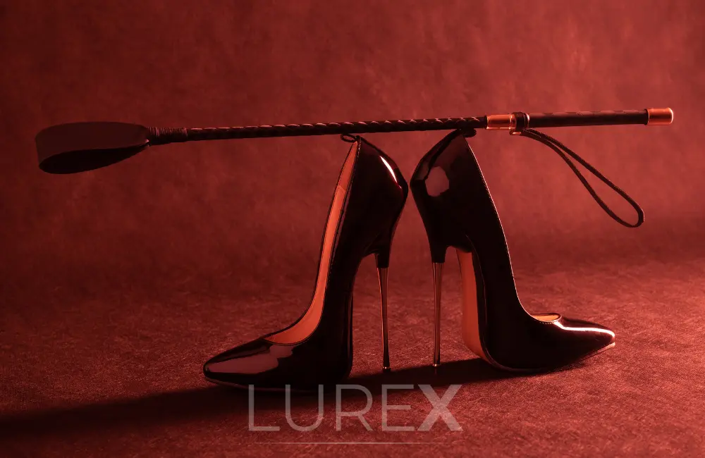 Fekete magassarkú cipő és paskoló, BDSM szerepjáték és dominancia szimbóluma.